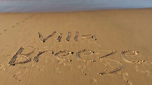 Une plage sur laquelle on a écrit dans le sable les mots « Vil Breeze ».