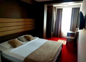 A hotel room with a bed, a desk, a chair, and a television. - Hotel Espana (East Sarajevo)