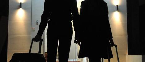 A silhouette of a couple walking towards a hotel entrance with a sign reading "HOTEL ESPAÑA".