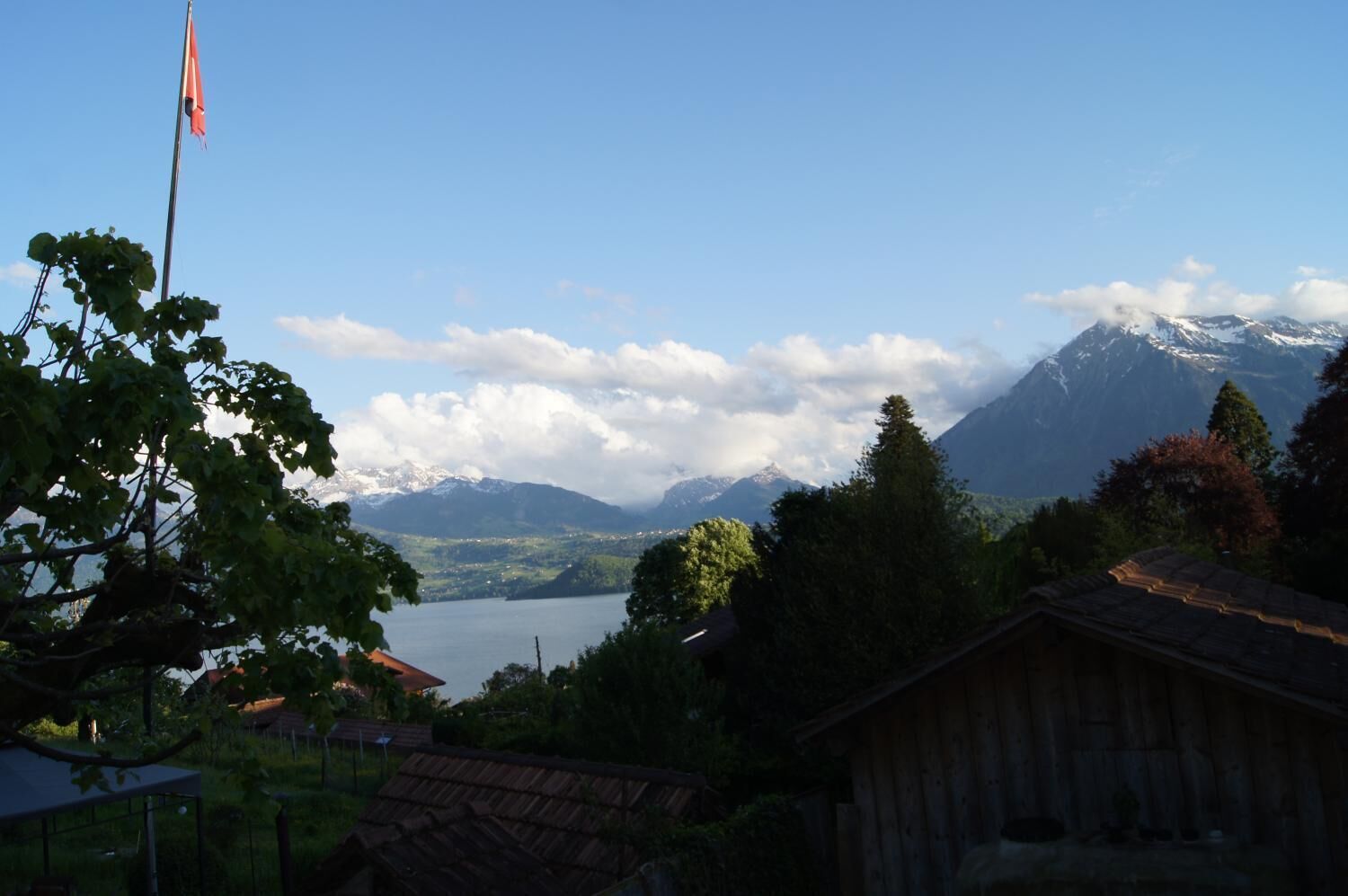 Eine Berglandschaft mit einem See, einer Flagge und einem Holzhaus.