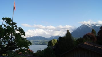 Eine Berglandschaft mit einem See, einer Flagge und einem Holzhaus.