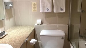 Kylpyhuoneessa on wc, pesuallas ja suihku. Pyyhkeet on pinottu hyllylle wc:n yläpuolelle.