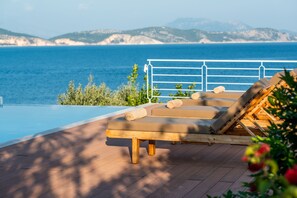 A wooden deck with lounge chairs and a pool overlooking a coastal landscape. - Iris Villas Lefkada - Karavi Villa (Lefkada)