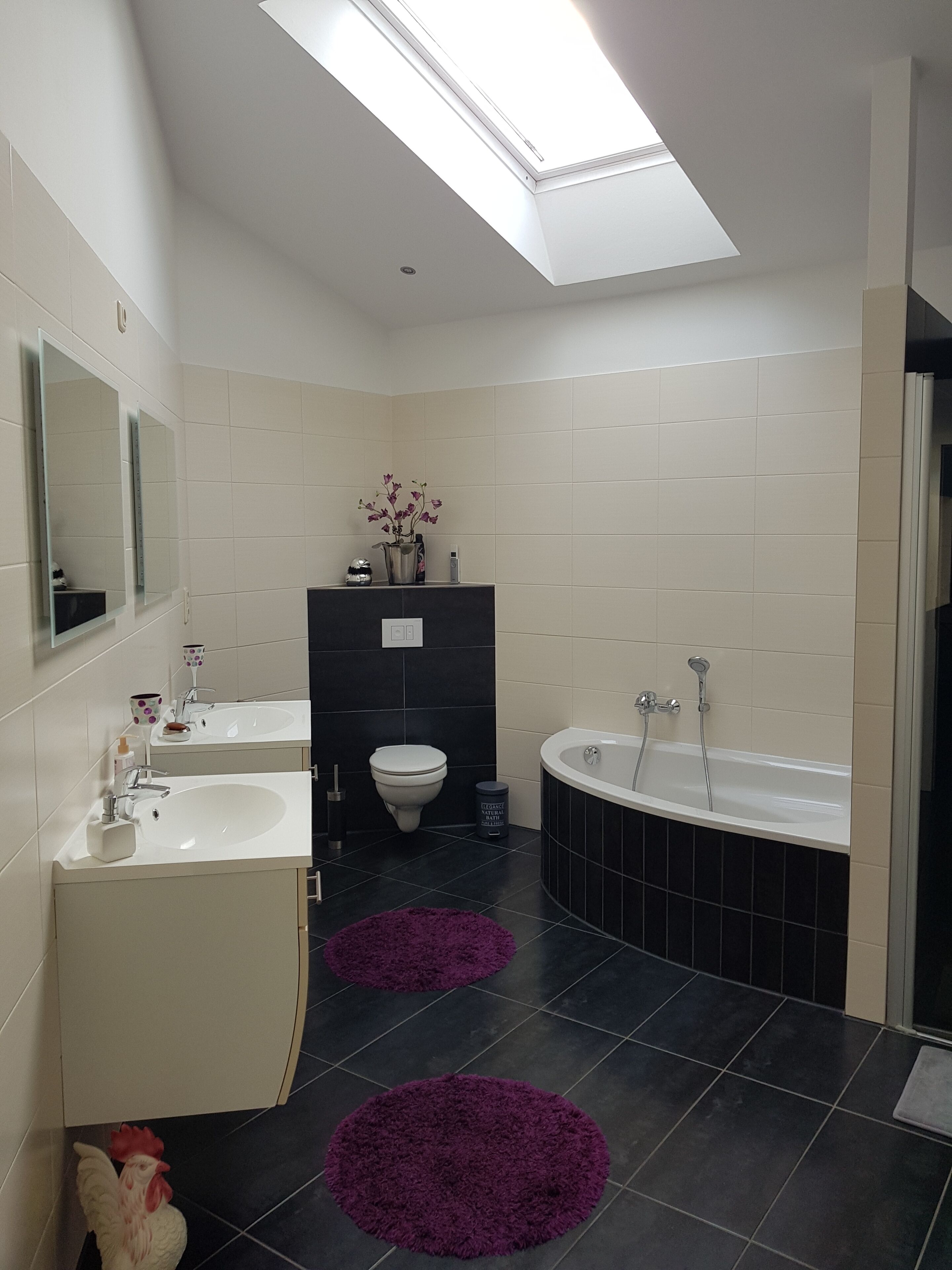 Un baño moderno con dos lavamanos, un inodoro y una bañera.