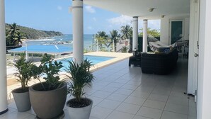 A covered outdoor area with a pool, potted plants, and a welcome mat. - OCEAN VIEW VILLA WITH PRIVATE POOL, STEPS FROM SECLUDED BEACH, GATED COMMUNITY! (Yabucoa)