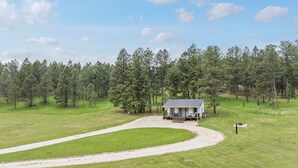 A small cabin with a porch, surrounded by a forest and a dirt path. - Historic Ranger Station in the heart of Nemo, SD (Nemo)