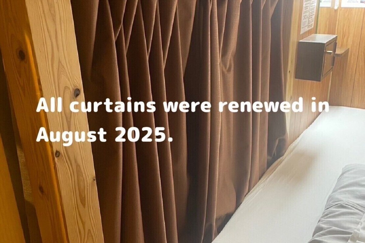 A room with wooden walls and a bed with white bedding.
