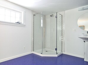 Een bad/douchecombinatie, handdoeken, zeep, toiletpapier