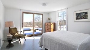 A bedroom with a bed, a chair, a dresser, and a lamp. - Fabulous Cottage on Pristine Broad Bay (Waldoboro)