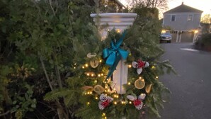 A mailbox decorated with a Christmas wreath, lights, and a blue bow. - BEAUTIFUL COTTAGE on ORANGE ST, WALK TO MAIN STREET! (Nantucket)
