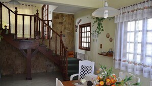 A dining area with a wooden table, chairs, and a staircase. - Cozy House in Gated Community -3 bedrooms (1 suite)-3 bathrooms-Internet (Massaguaçu)