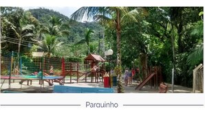 A park with a swing set, climbing structures, and a small shelter. - Cozy House in Gated Community -3 bedrooms (1 suite)-3 bathrooms-Internet (Massaguaçu)