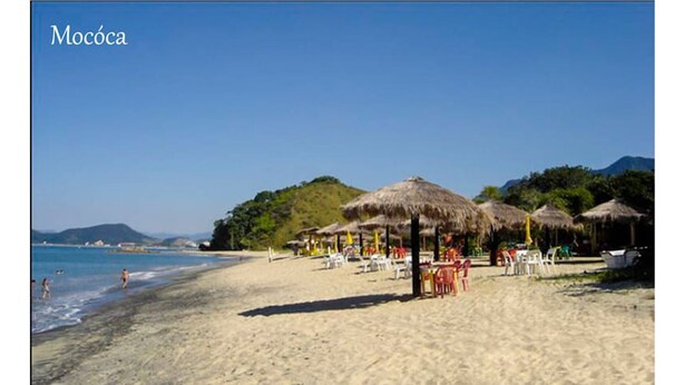 A beach with thatched umbrellas and beach chairs, a clear sky, and a calm sea. - Cozy House in Gated Community -3 bedrooms (1 suite)-3 bathrooms-Internet (Massaguaçu)
