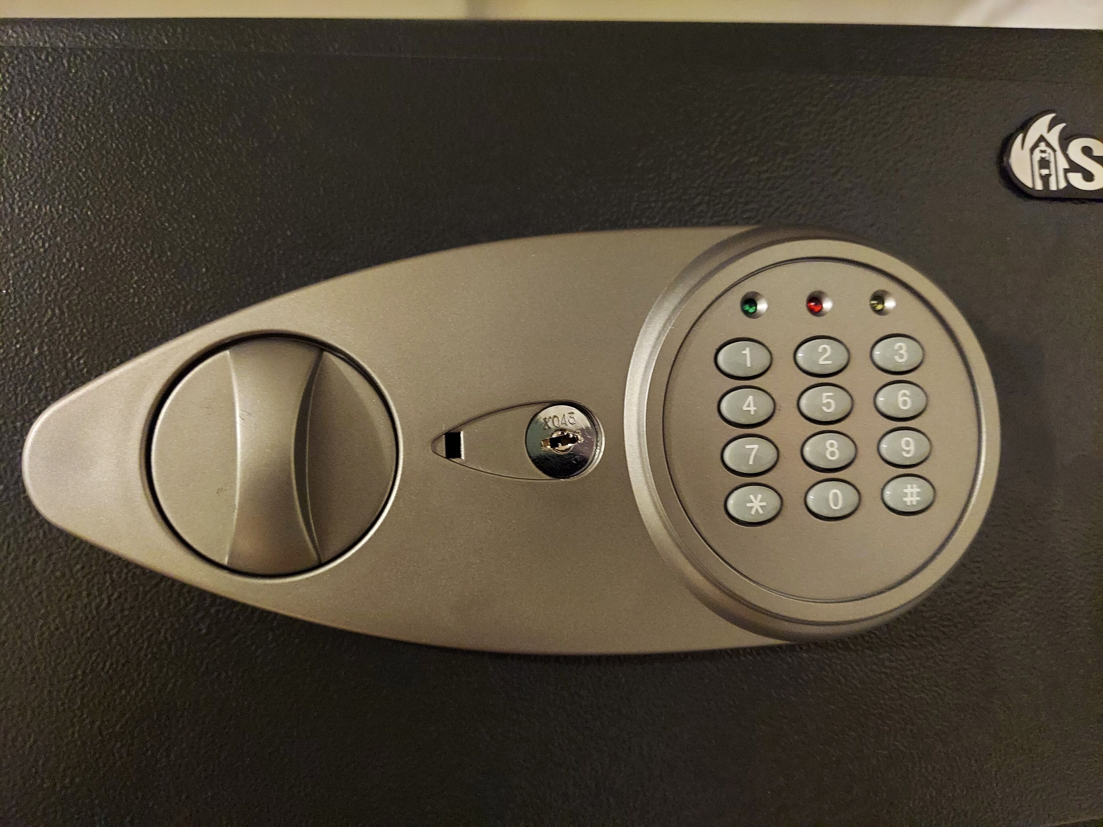 Een keypad slot op een deur, met een sleutelgat en een klein raampje.