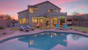 A two-story house with a swimming pool, outdoor seating, and a patio area. - Golf Course & Mt VIEWS: Htd POOL, Hot Tub, Putting Green, Fire Pit, 3 Bikes (Mesa)