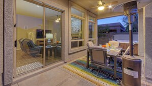 A patio area with a table, chairs, and a heater. - Golf Course & Mt VIEWS: Htd POOL, Hot Tub, Putting Green, Fire Pit, 3 Bikes (Mesa)