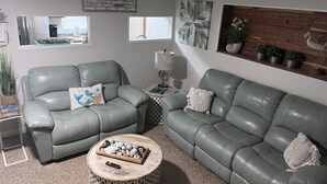 A living room with two grey leather sofas, a wooden coffee table, and decorative pillows. - SASSA MERMAID WATERFRONT HOUSE WITH KAYAKS AND POOL (Homosassa)