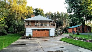 A two-story log cabin with a large garage and a balcony.