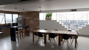 Eine moderne Küche mit Essbereich, einer Treppe und einem großen Fenster.