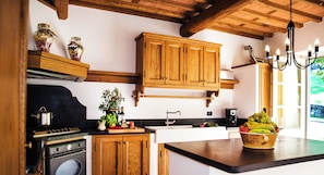 Una cocina con armarios de madera, una estufa y un tazón de fruta en la encimera.