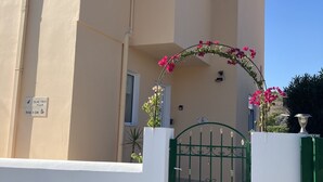 A building with a beige facade, a green gate, and a sign indicating 'Olivine Tree Villa'. - Nineteen 5* reviews. Book 2025 now (Lardos)