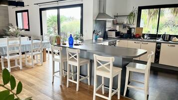 Enjoy cooking in this well-equipped kitchen with a large island, stainless steel range hood, and microwave.