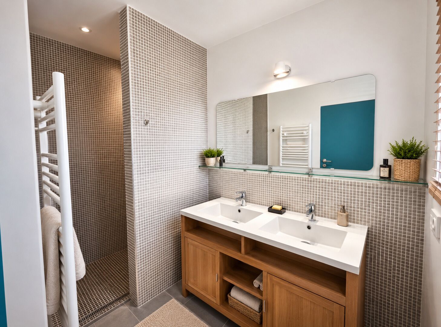 Une salle de bain moderne avec deux vasques, une douche en verre, un meuble-lavabo en bois et un grand miroir.