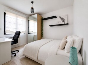 Un dormitorio moderno con una cama, un escritorio y una silla.