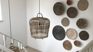 A staircase with white railings and a wall decorated with various woven wall hangings.
