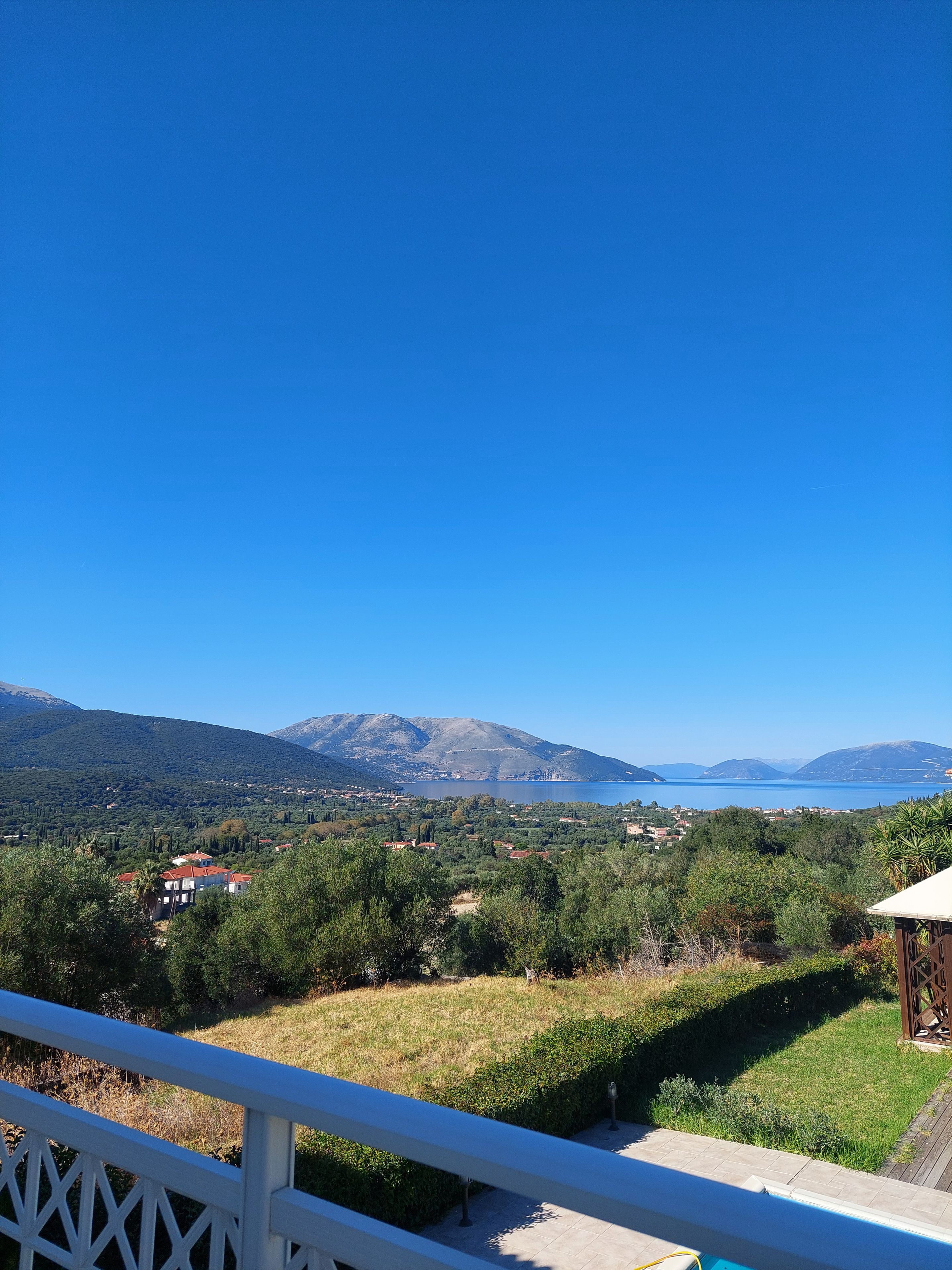 A view from a balcony overlooking a mountainous landscape with a clear sky.
