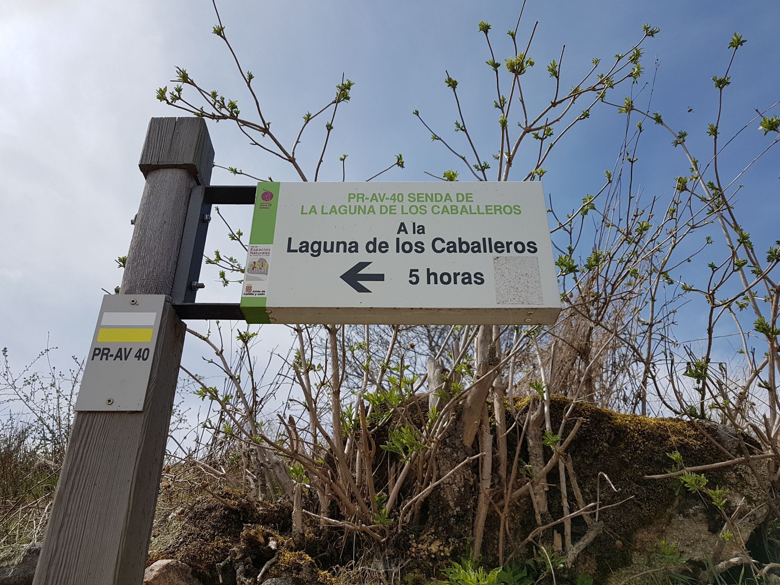 A directional sign for Laguna de los Caballeros with a 5-hour travel time indication.