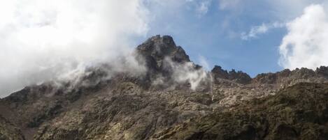 Un pico montañoso escarpado con nubes que lo cubren parcialmente.