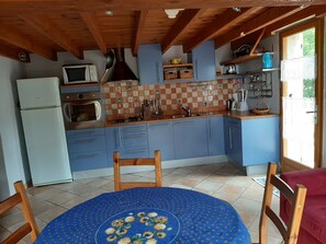 Enjoy meals in this kitchen with a refrigerator, microwave, and dining table.