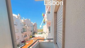 Un balcón estrecho con vistas a edificios y una bandera.