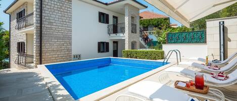 Lämmitetty uima-allas, aurinkotuoleja