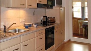 A compact kitchen with a sink, stove, microwave, and cabinets.