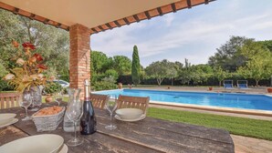 A poolside dining area with a table set for two, a bottle of wine, and a vase of flowers. - Beautiful home in Orbetello -GR- (Orbetello -GR-)