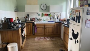 Une cuisine avec des armoires en bois, un évier, une cuisinière et un réfrigérateur.