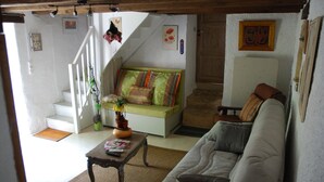 Un salon avec un canapé, une table basse et un escalier menant à un autre niveau.