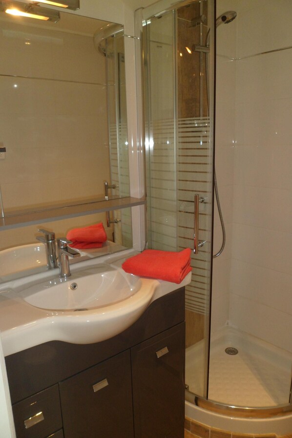 A bathroom with a glass-enclosed shower, a sink with a mirror, and a towel rack. - Villa fully air-conditioned, panoramic view. between sea, lake and Verdon (Draguignan)