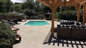 A backyard with a swimming pool, lounge chairs, a wooden pergola, and a wicker sofa. - A FEW STEPS FROM THE SEA, MAS DES PORTALS CRIQUES MAGNIFICENT VIEW, (COLLIOURE)