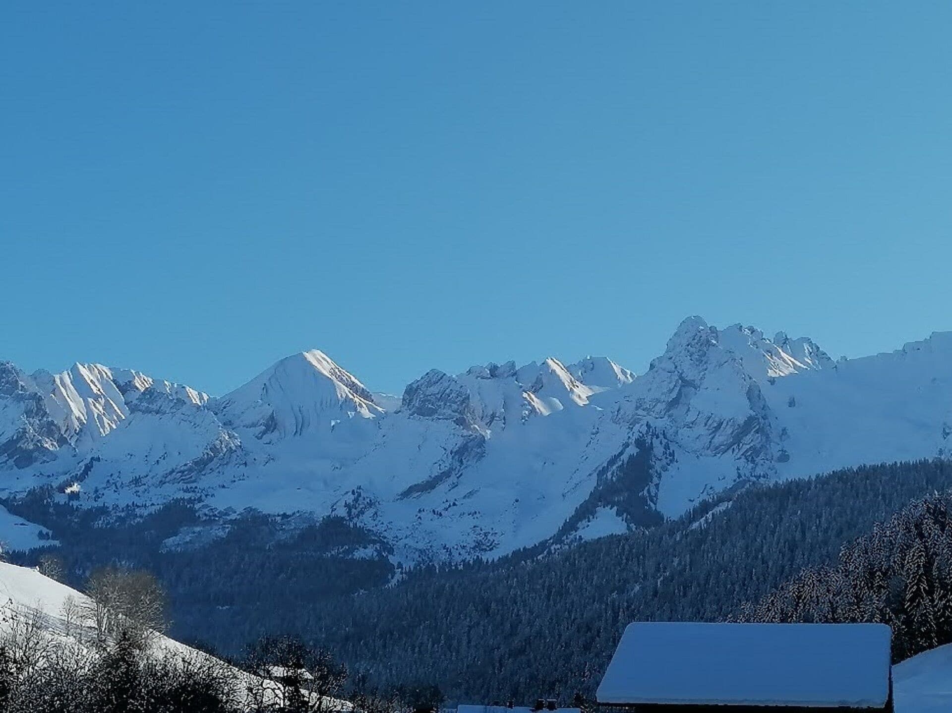 Ein Gebirge mit schneebedeckten Gipfeln und blauem Himmel.