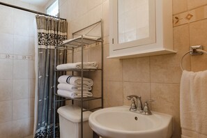 A bathroom with a shower, toilet, sink, and towel rack. - A Relaxing Retreat in the Punta Chame Area. Your Perfect Escape Awaits! (Chame)