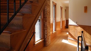 A wooden staircase with a metal railing leading to a landing. - Contemporary Apartment in Historic 1895 Building (Hardwick)