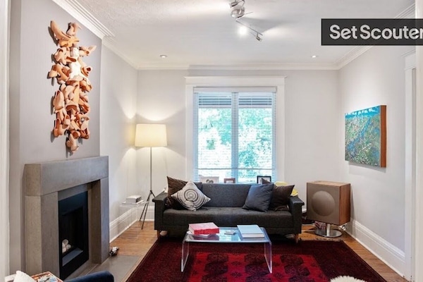 The living room, with original art, Persian rug, fireplace.