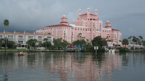 A large pink hotel with multiple towers and a waterfront view. - Dunes, Daisies, Surf, Sand, Sunsets...Historic BUTLERHOUSE,  Pass-a-Grille (St. Pete  Beach)