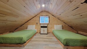 A small, cozy attic bedroom with two single beds, a small cabinet, and a window. - Sight distance of Lake Superior Beach, Autrain River, Close to Pictured Rocks (Au Train)
