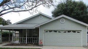 A single-story house with a garage, a covered porch, and a small front yard.