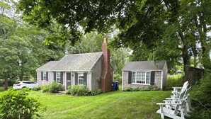 A house with a small attached garage, a lawn, and outdoor seating. - Peaceful hideaway on Westport Point (Westport)
