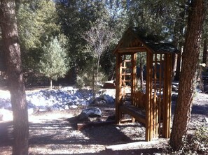 A wooden gazebo in a forested area with a stone path and rocks. - Autumn is beautiful in the mountains.  We welcome you, and we're pet-friendly! (Pine Mountain Club)